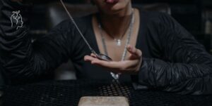 Femme tenant un pendule dans ses mains