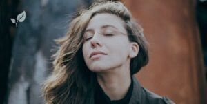 Jeune femme en train de fermer les yeux et respirer