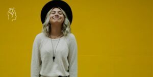 Jeune femme sur fond jaune heureuse