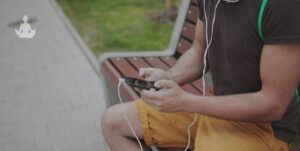 Personne en train d'écouter des méditations sur son téléphone avec ses écouteurs