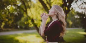 Jeune femme blonde en train de méditer dans un champs