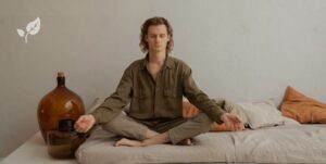 Jeune homme en train de méditer sur son sofa