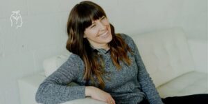 Femme assise sur un sofa qui rigole