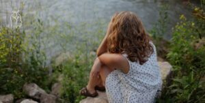 Femme dans la nature qui prend sa tête dans ses mains