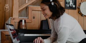 Jeune femme en train de suivre une formation en ligne en écoutant dans son casque audio