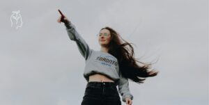 Jeune femme en train de tendre le bras vers le ciel