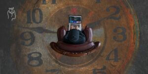 Homme assise sur une horloge immense