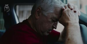 homme dans sa voiture se prenant la tête entre les mains